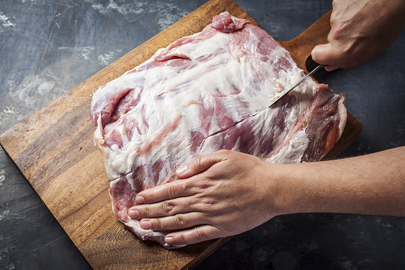 Slice across the meat covering the bones at the centre point of the rack.