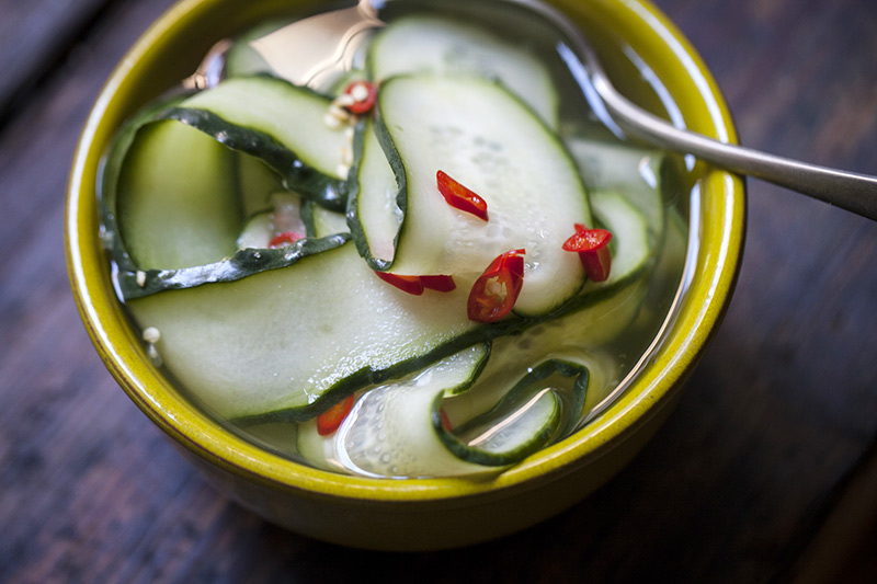 As a side dish to the pork, try simply slicing cucumber finely, and mixing it with equal parts water and white vinegar. Season only with a touch of sugar, salt and finely sliced Thai chillies.